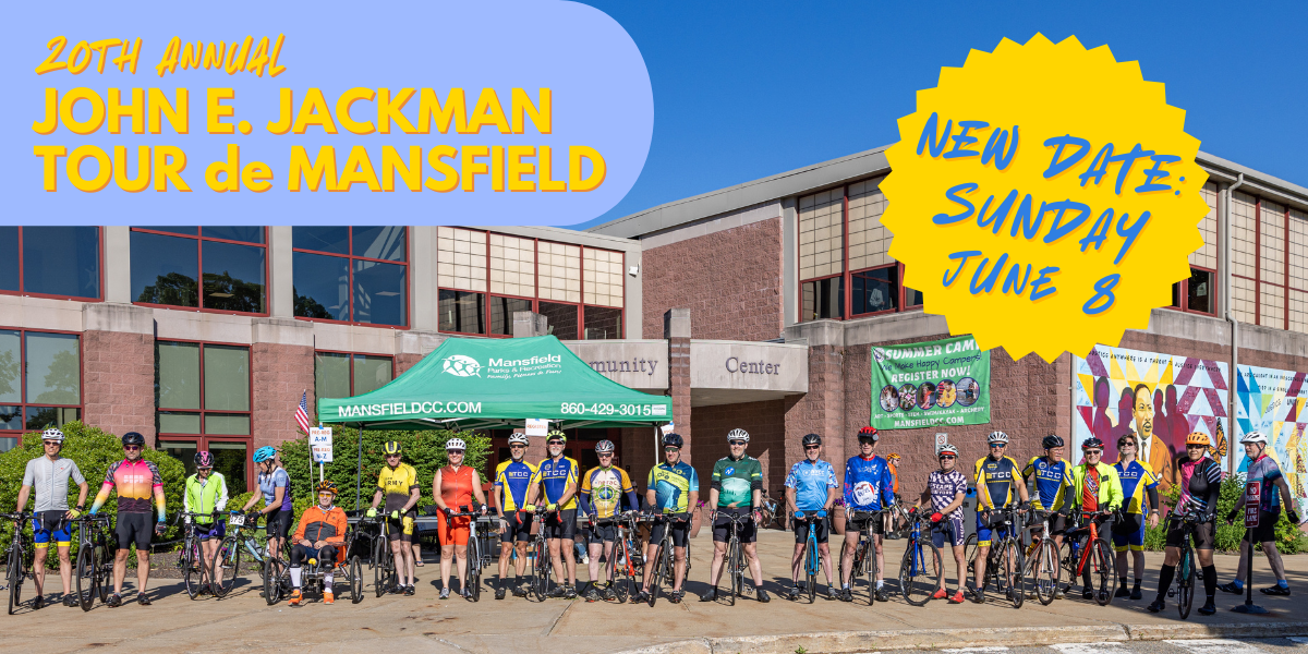A group of cyclists pose with the bicycles in front of Mansfield Community Center
